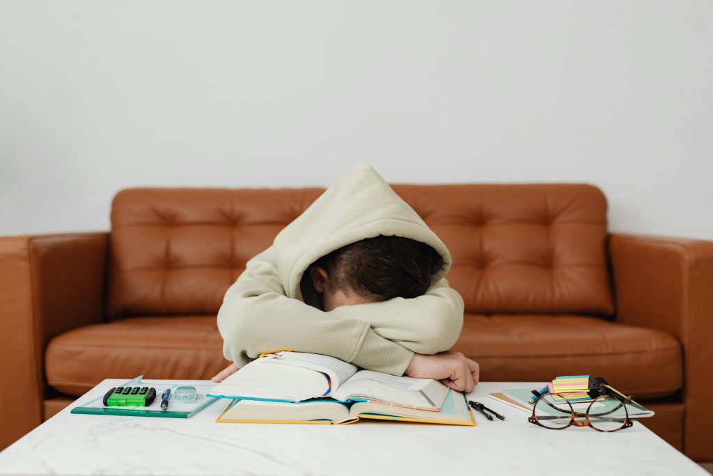 Student struggling with homework alone at home, illustrating the impact of online tutoring and educational inequality in the UK.